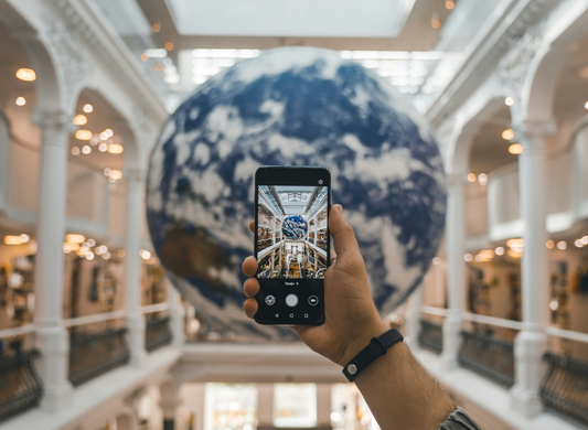 Hand with phone taking a picture inside a book shop. Photo by Alexandr Bormotin on Unsplash