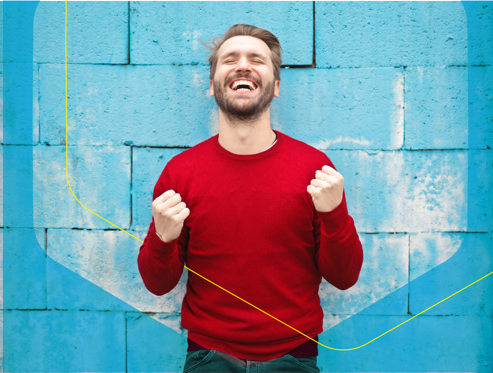 tanar bucuros in fata unui perete albastru